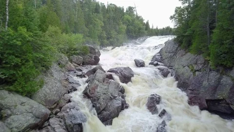 Low level aerial drone shot of raging river in a forest Video stock 79610482