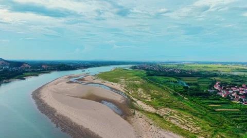 Low level drone flyover above fertile riverbank and distant rural villages 4K Vídeo Stock 340747726