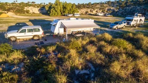 Low level drone view of a 4WD and a caravan in the  at a free camp near the b Stock Photos