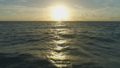 Low Level Flight over Sea at Sunrise. Aerial Reveal Shot Stock Footage 100037858