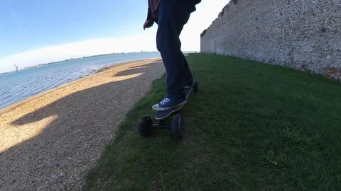 Low level parallax shot of a man riding an electric skateboard, travelling Video stock 107001996