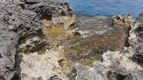 Low Level Shot, Sandy Rocky Rocks Seaweed With Slow Waves Moving In and Out Stock Footage 34256765