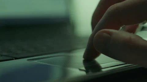 In low light conditions a hacker programmer works on his laptop, manipulatin Stock-Footage 254892025