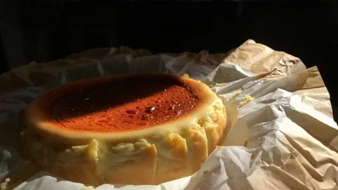 Low light footage of basque burnt cheesecake in black background. Stock Footage 130942710