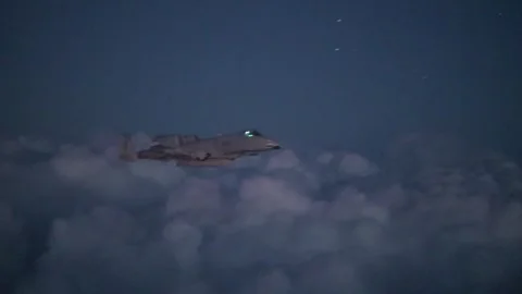 Low light imagery U.S. Air Force A-10 Thunderbolt II flying above clouds at dusk Stock Footage 297066878