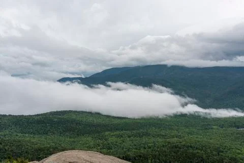 Low lying clouds overtake the green landscape Stock Photos