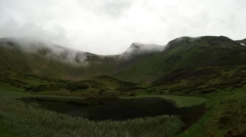 Low misty clouds escape the mirror mountain lake to the heights of the mountains Stock Footage 40745136