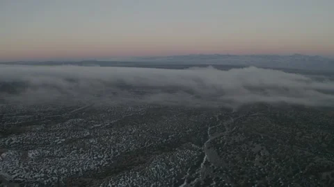 Low misty clouds roll over a western desert landscape in New Mexico from drone Stock Footage 167668792
