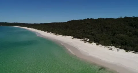 Low over white sandy beach and shallow bay of Jervis Bay in aerial hover 4k. Stock Footage 138928161
