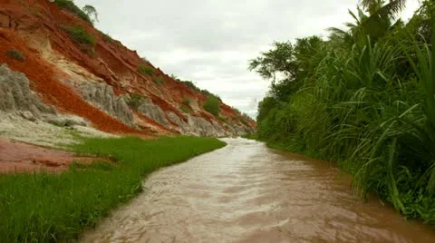 Low pan to red and white rocks and sand dunes in river canyon. Stock Footage 11436483