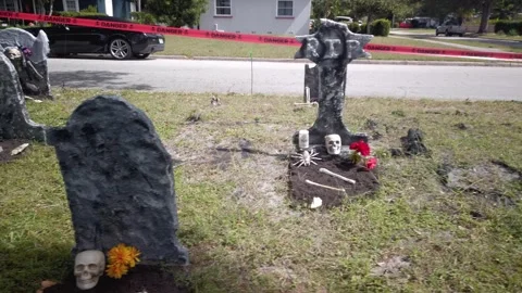 Low Pan from street right to left Halloween Decorations. In the daytime sun Stock Footage 253521311