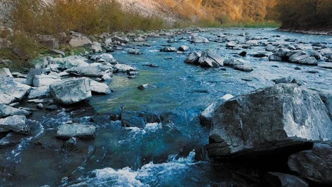 Low panoramic flight over the rushing mountain river, and crystal turquoise Stock Footage 92123417
