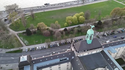 Low pass above riverside building with eagle sculpture Stock Footage 333060567