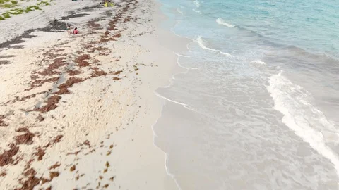 A low pass shot of waves and swimmers on the beach of Isla Blanca near Cancun Stock Footage 104121797