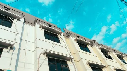 Low perspective modern beige building exterior with repeating windows and e.. Stock-Fotos