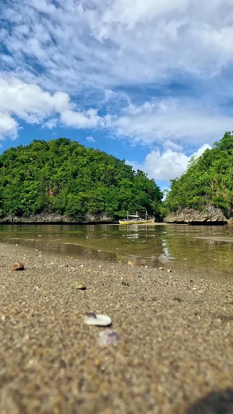 Low perspective view of an outrigger boat or bangka floating peacefully in Video stock 330995665