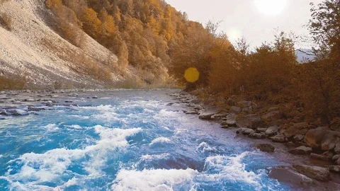 Low rapid flight over the rushing mountain river, blue in the mountains. Sunset Video stock 92130009