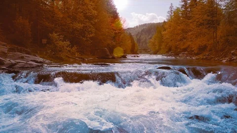 A low rapid flight over the rushing mountain river, blue in the middle of the Stock Footage 92130899