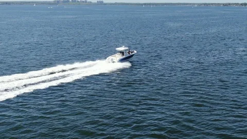 Low, right-rear, side, tracking, aerial of speed boat on a nice sunny day 스톡 동영상 114020965