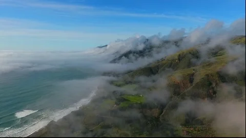 Low Rolling Clouds over coastline mountains (16:9) Stock Footage
