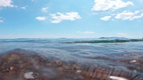 Low Sea-Surface Perspective with Small Swell on Pebbly Greek Shore Stock Footage 344596256