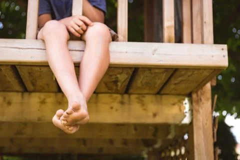 Low section of boy relaxing in log cabin Stock Photos