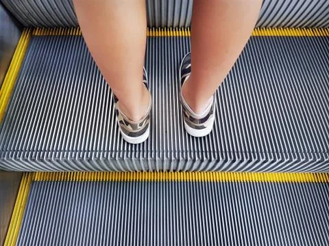 Low Section of Boy Standing on Escalator Foto stock