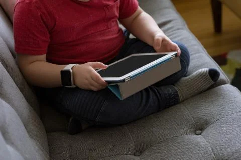 Low section of boy using tablet computer Fotos de archivo
