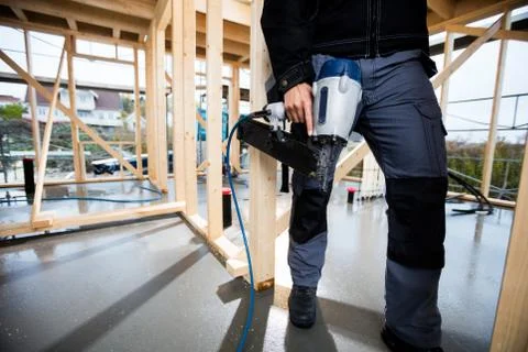 Low Section Of Carpenter Holding Drill At Site Foto stock