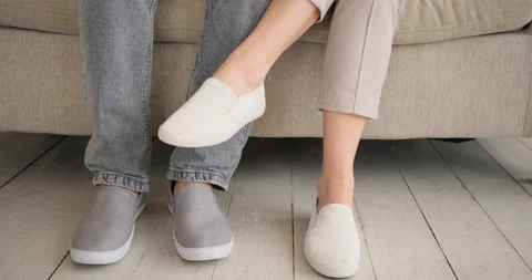Low section of couple sitting on sofa and romancing Stock Footage 145216097