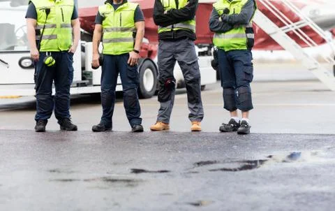 Low Section Of Ground Crew Standing On Runway 写真素材