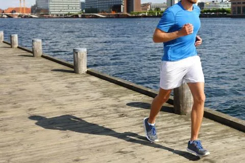 Low Section Of Man Jogging On Boardwalk By River Stock Photos