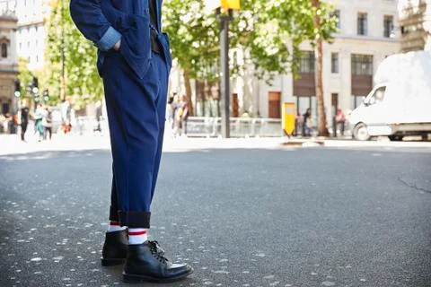 Low section of a man in navy blue trousers and black boots Stock Photos