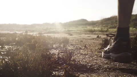 Low section of man running through marsh land in slow motion Stock Footage 71566306