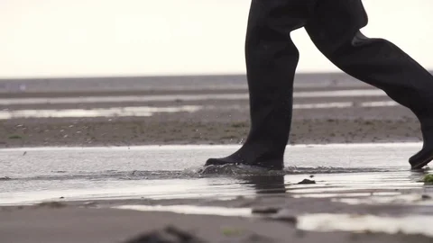 Low section of a man walking through tidal pool on beach in slow motion Stock Footage 71566533