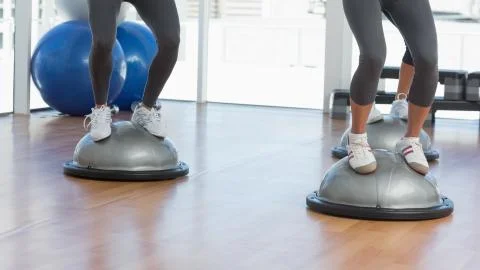 Low section of people performing step aerobics exercise Stock Photos