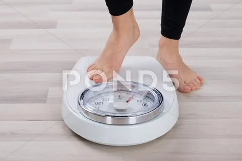 Low Section Of Person Standing On Weighing Scale Stock Photos