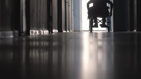 Low section of Silhouette of Disabled Patient Riding Wheelchair Stock Footage 100797105