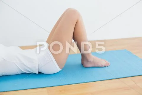 Low section of sporty woman lying on exercise mat Stock Photos