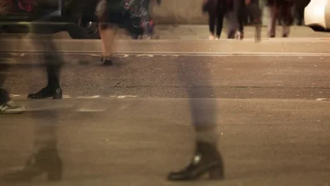 Low section time-lapse of anonymous commuters crossing a road at night Video stock 71841152