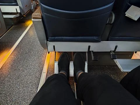 Low section view of passenger sitting on train seat during travel Stock Photos
