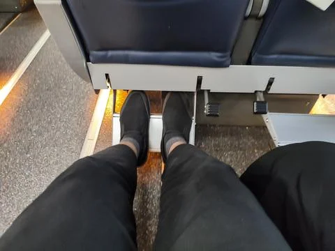 Low section view of passenger sitting on train seat during travel Stock Photos