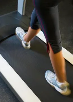 Low section of woman walking on treadmill Stock Photos