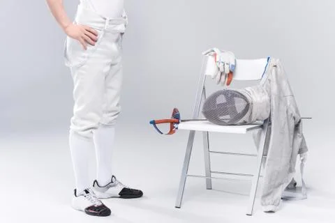 Low section of young man professional fencer standing near chair with fenci.. Stock Photos