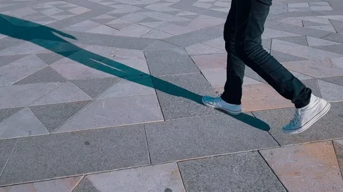 Low section of a young man with white sneakers walking on ground 스톡 동영상 98408445