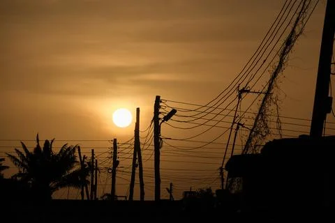 Low setting full round sun with electricity and telephone cable Stock Photos