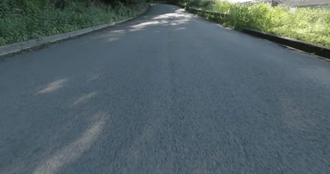 Low Shot of Asphalt Road Without Vehicles Next to Wooded Area - Evening / Sunset Stock Footage 201281661