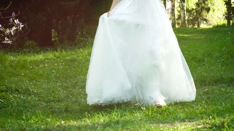 Low shot of bride turning around in sunny garden in slow motion Stock Footage 104411617