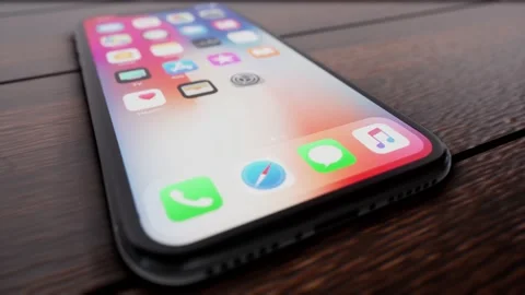 A Low shot sliding right away from unlocked cellphone on desk Stock Footage 155220283