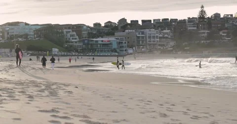 Low shot of surfers exiting the surf early in the morning Stock Footage 137624596